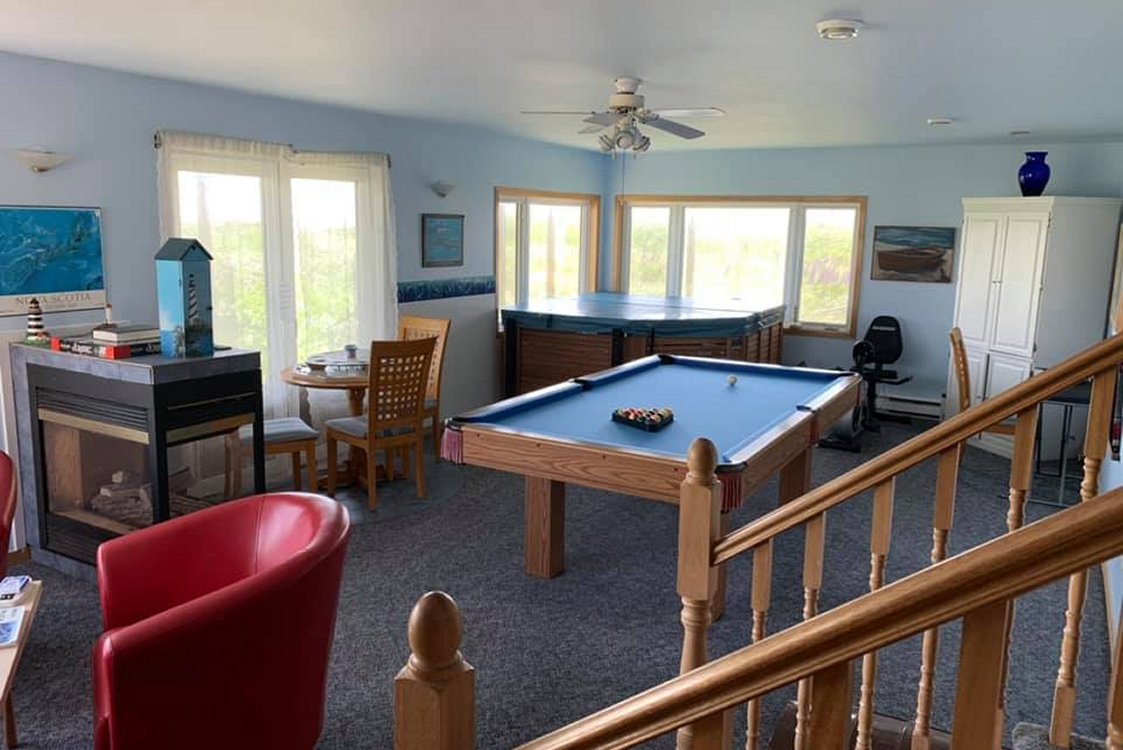 Common Room for guests, large windows with ocean views, pool table, hot tub, fireplace.